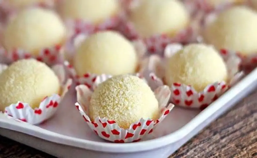 Imagem de brigadeiros de leite em pó, cobertos com leite em pó, dispostos em uma bandeja, prontos para serem servidos.