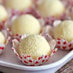 Imagem de brigadeiros de leite em pó, cobertos com leite em pó, dispostos em uma bandeja, prontos para serem servidos.